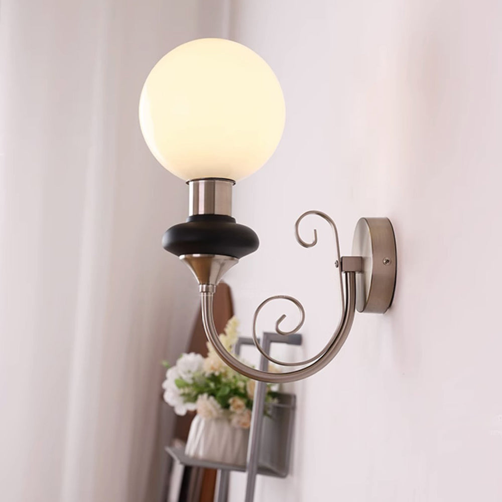 Side view of chrome-and-black wall sconce near a curtain