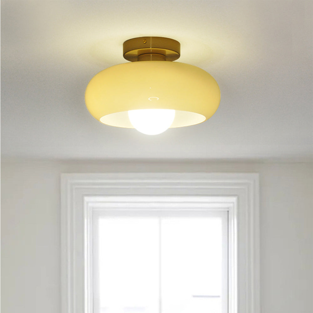 Gold and cream glass ceiling light above a bright window