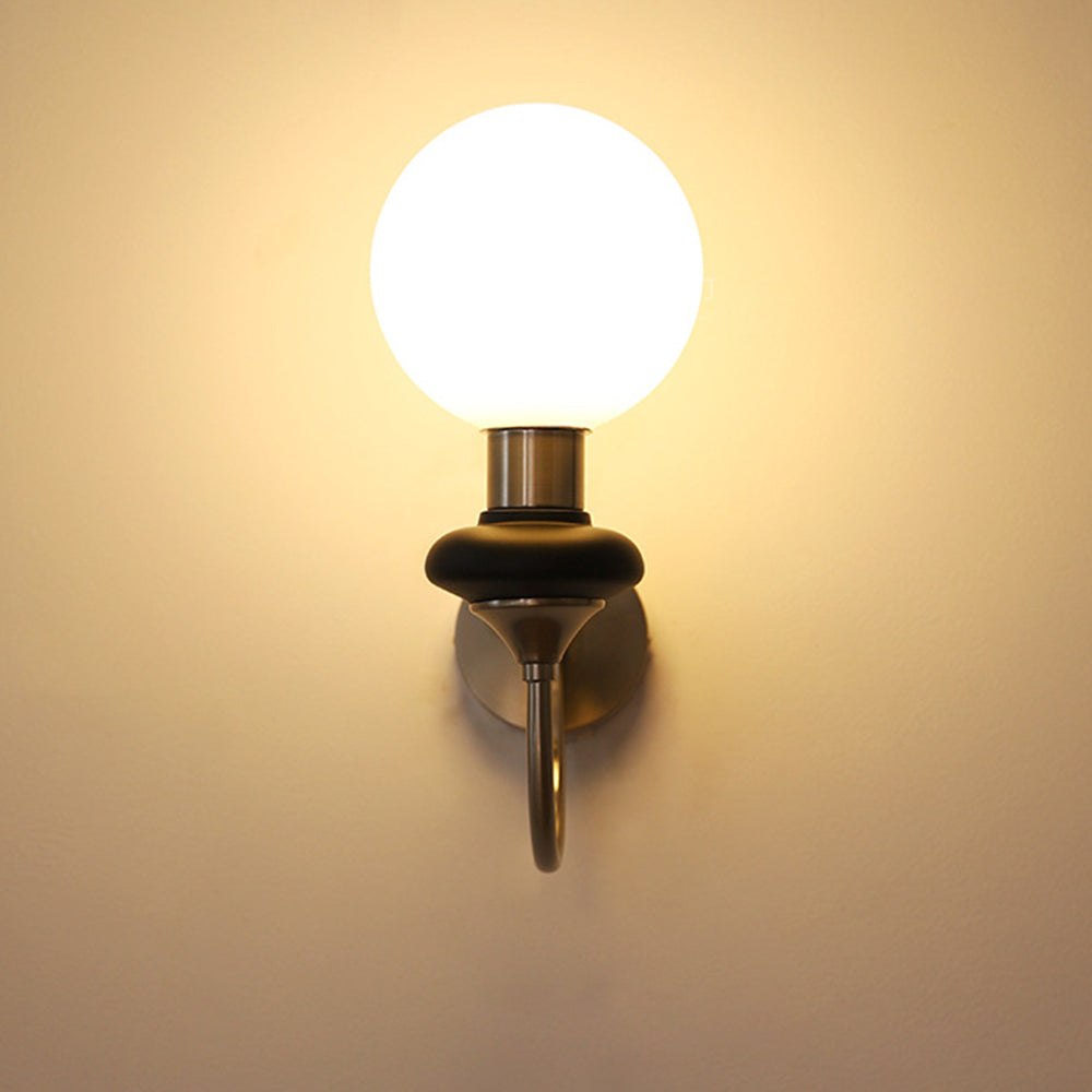 Front view of chrome-and-black sconce in a dark setting