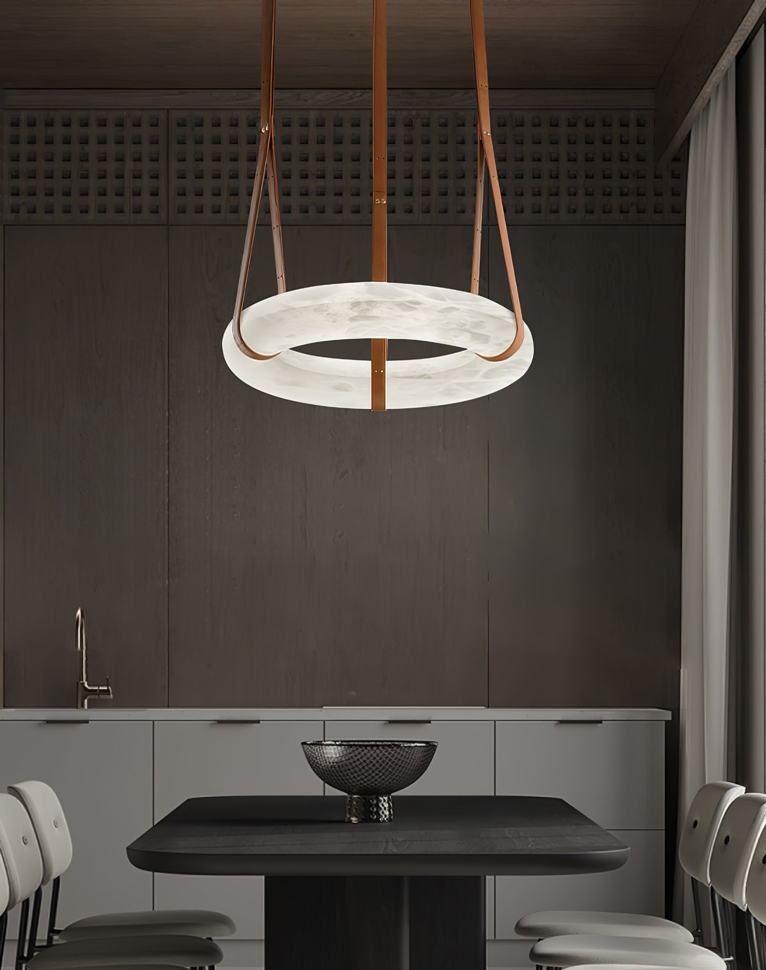 White alabaster ring hanging above a dark counter with a bowl.