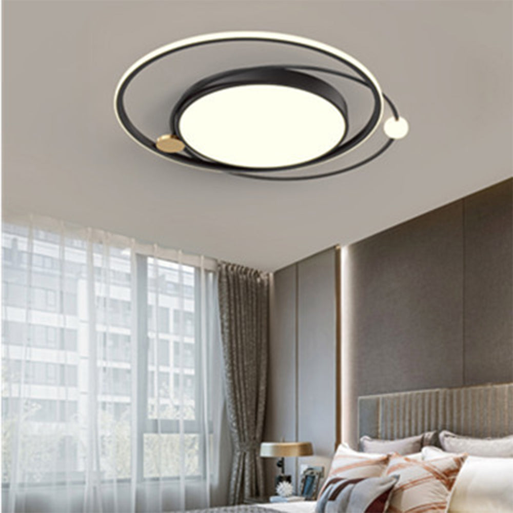 Black orbital ceiling fixture with bright central disk and white sphere above a bedroom with window and curtains