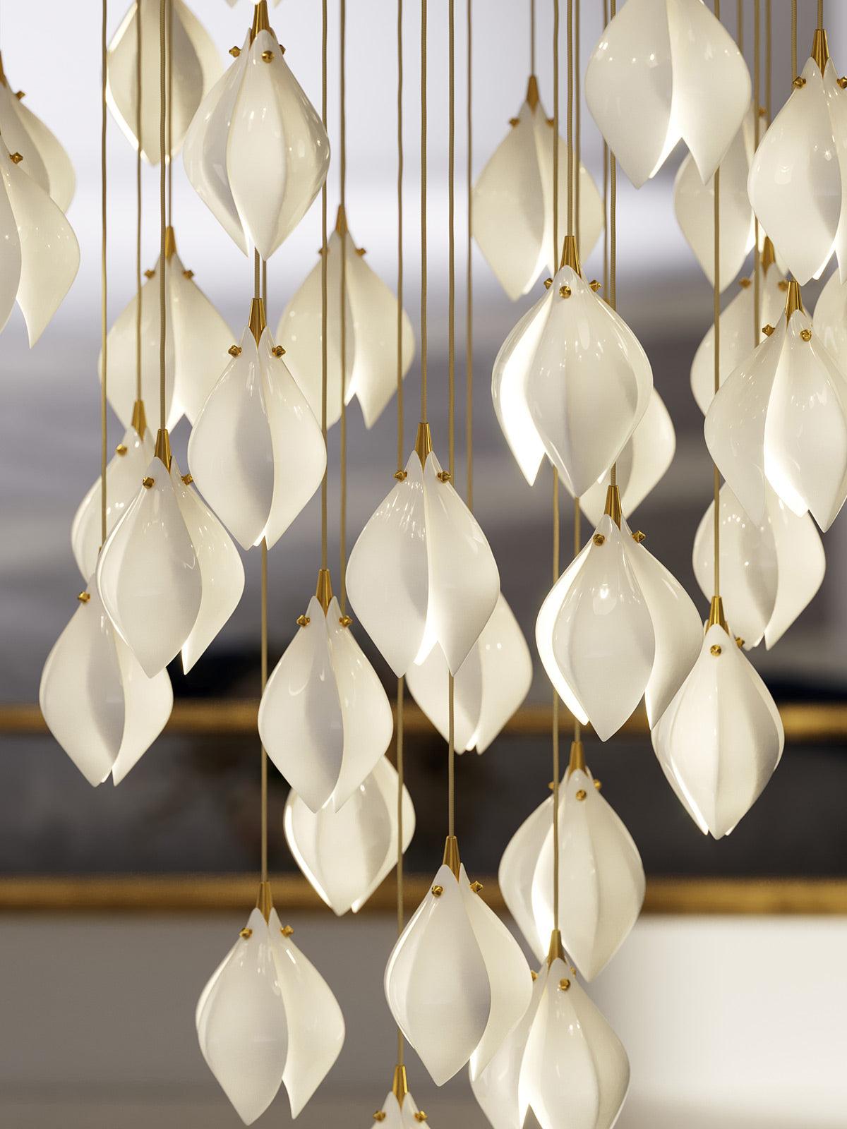 Glossy white flower petals and gold-tone cords in front of a gold mirror