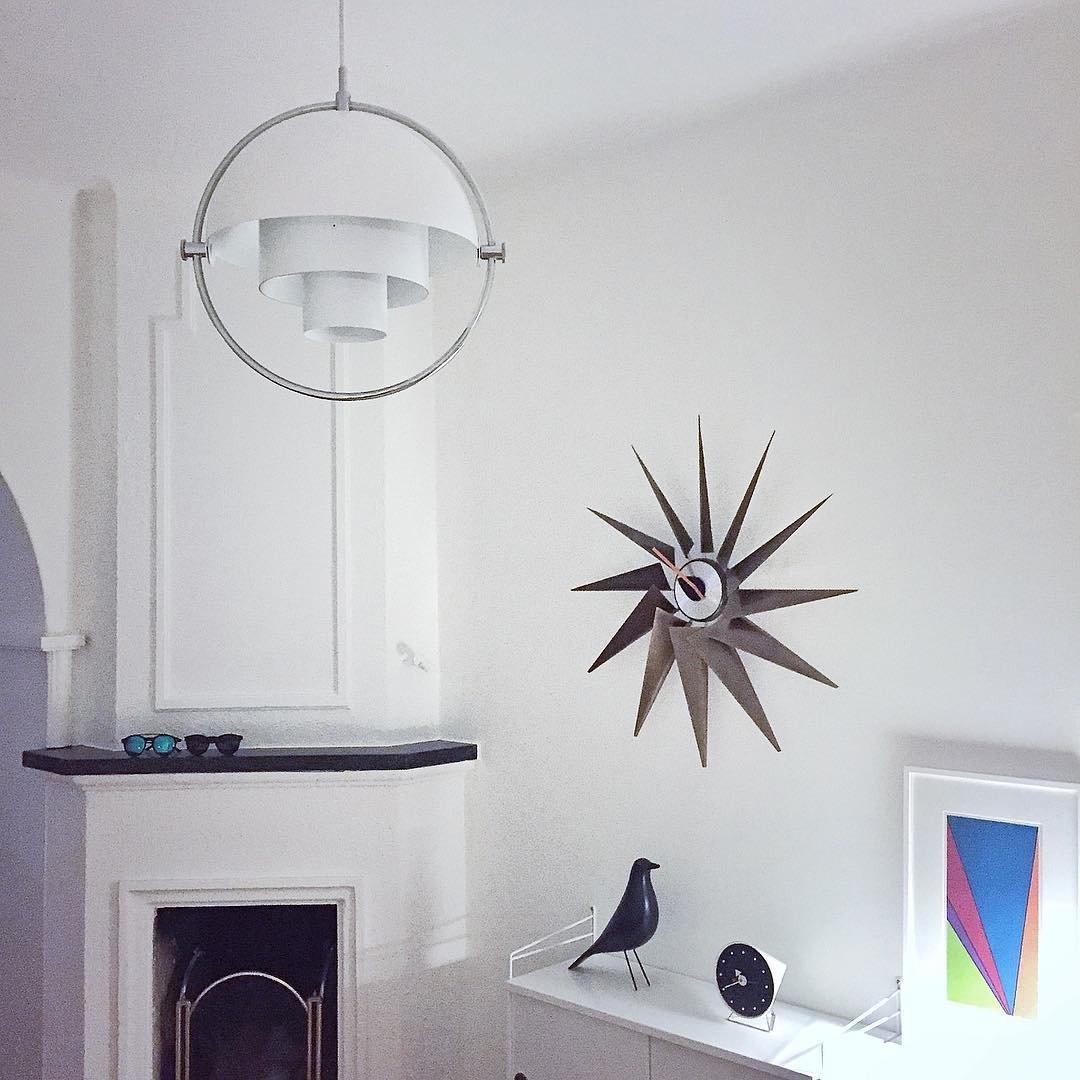 White shade pendant with a silver-coloured ring near a fireplace and star ornament.