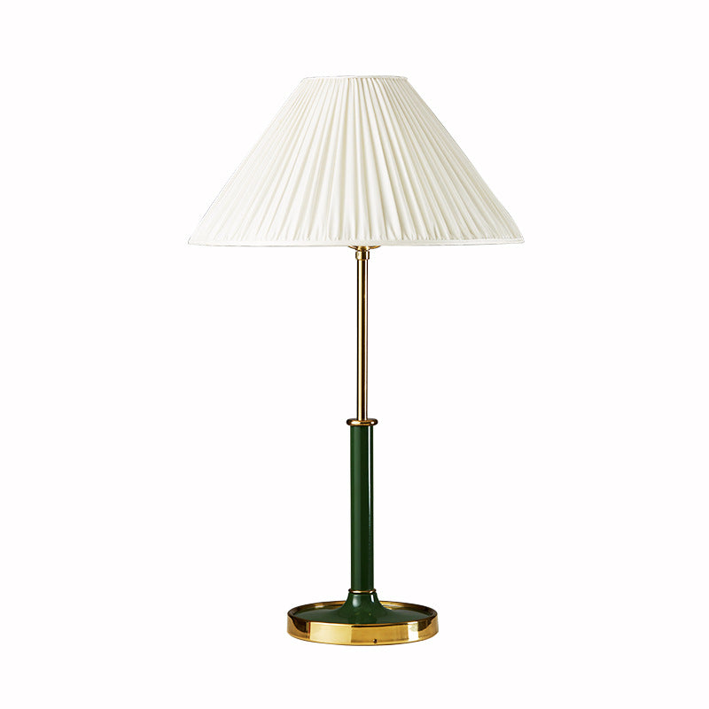 Isolated front view of white pleated conical shade above green lower stem, gold-toned upper stem and round base