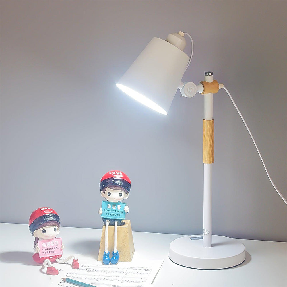 Lit White lamp on pale desk beside sheet music, pencil and two seated red-cap figurines, with cable at right