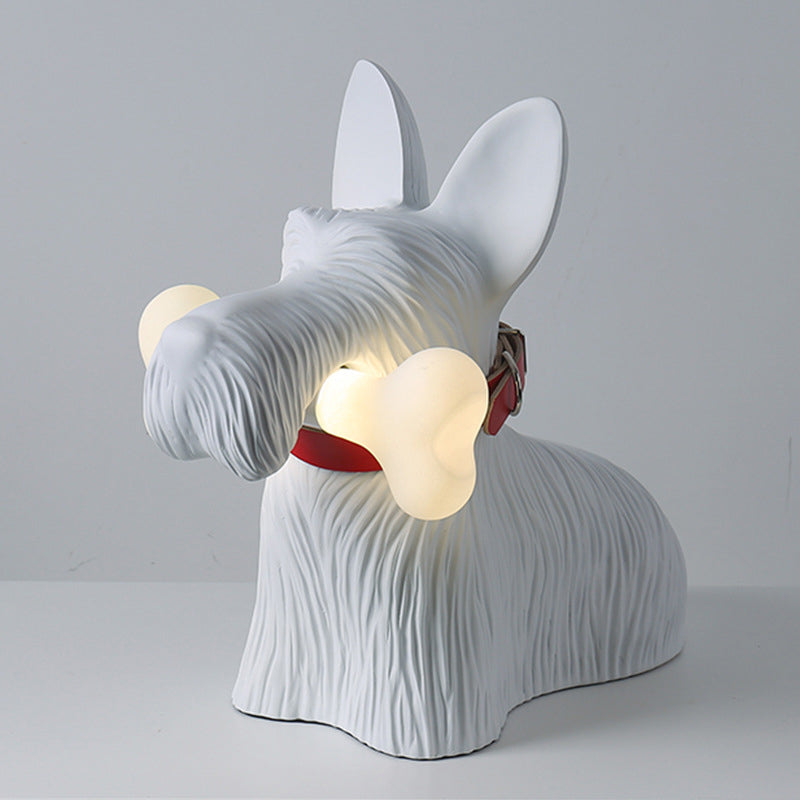 White dog lamp with upright ears, grooved fur and red collar holding a glowing bone against a plain background