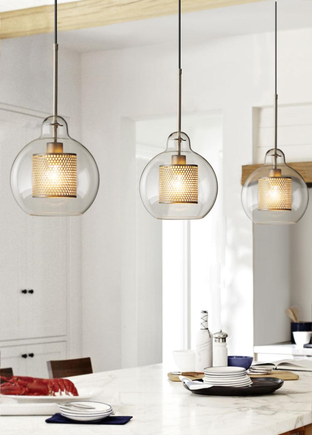Three glass pendants over a pale dining setting