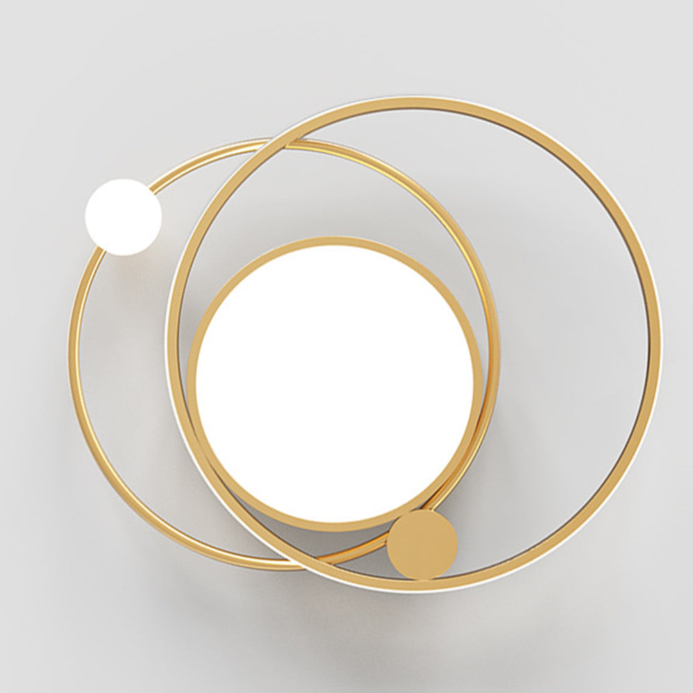 Underside view of gold-tone orbital ceiling fixture with circular diffuser, offset rings and sphere