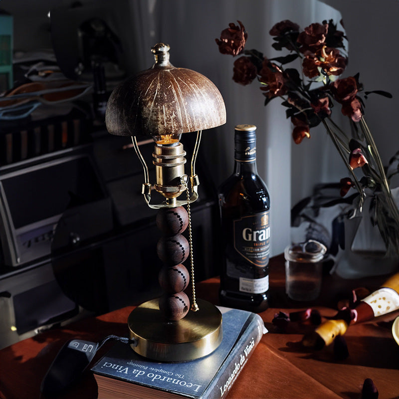Retro coconut-shell-detail lamp beside decorative bottles