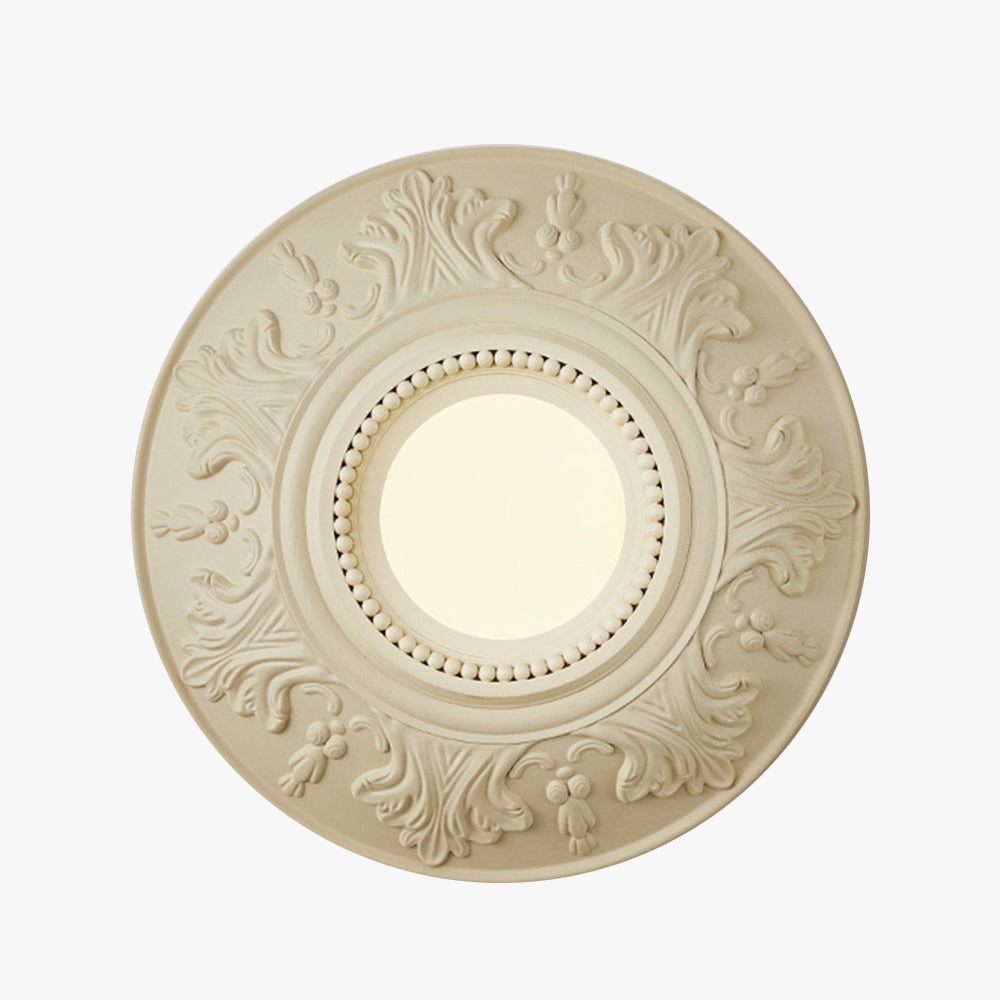 Isolated front view of cream ornamental circular wall light with central globe on white background