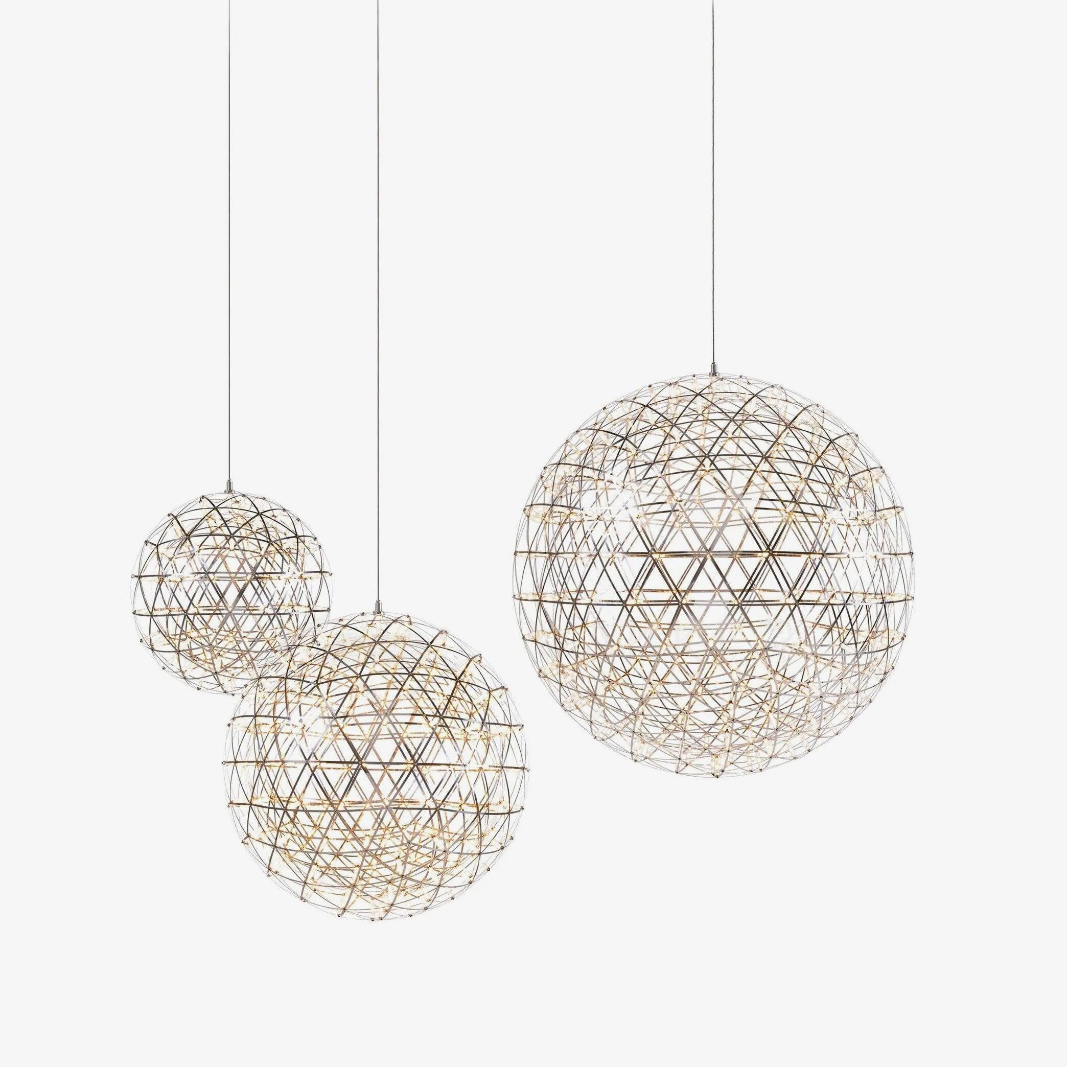 Three differently sized silver lattice globes on individual cords against white