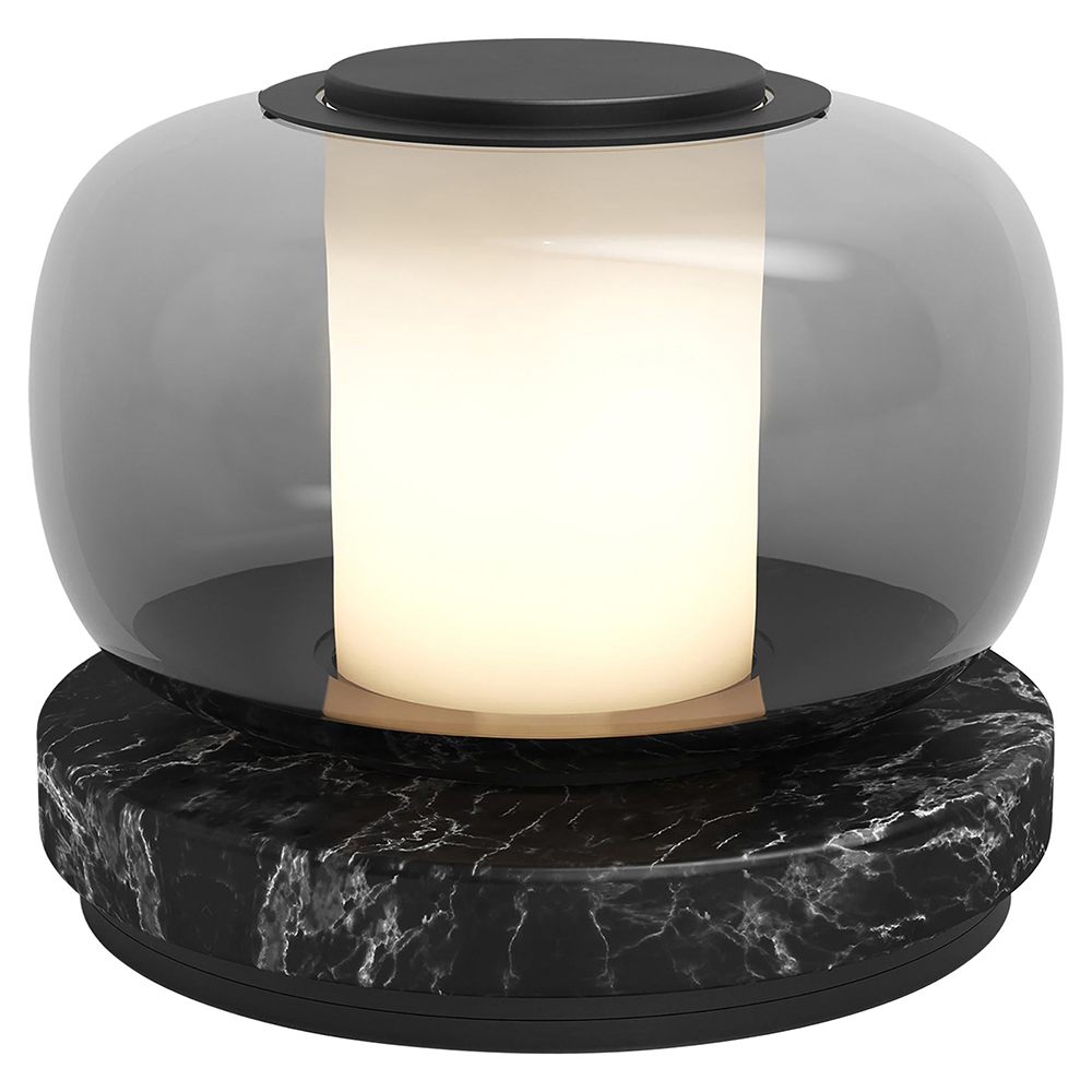 Close view of the pale glowing cylinder inside rounded smoky glass above a dark circular base with white veining
