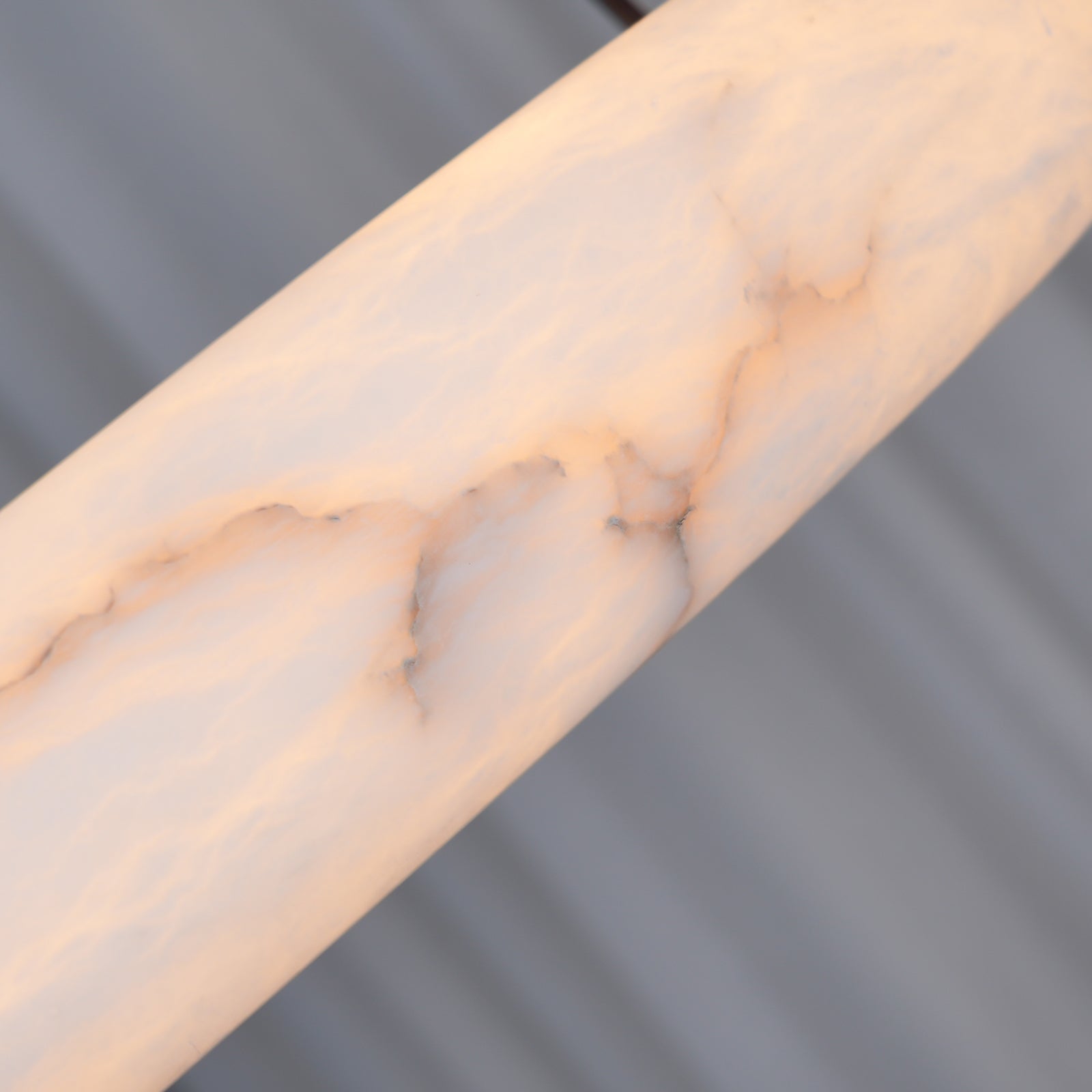 Close-up of pale veining across an illuminated alabaster ring surface.