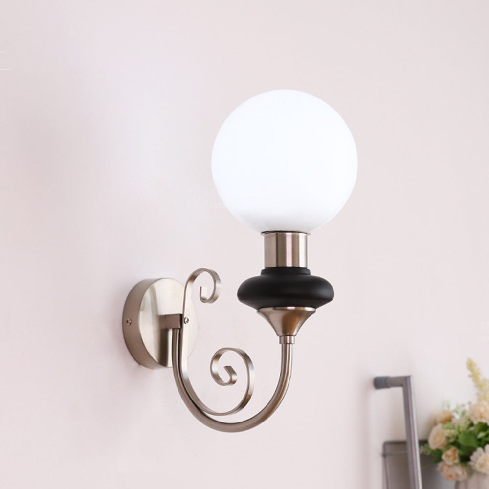 Bright globe on a chrome-and-black curled wall bracket