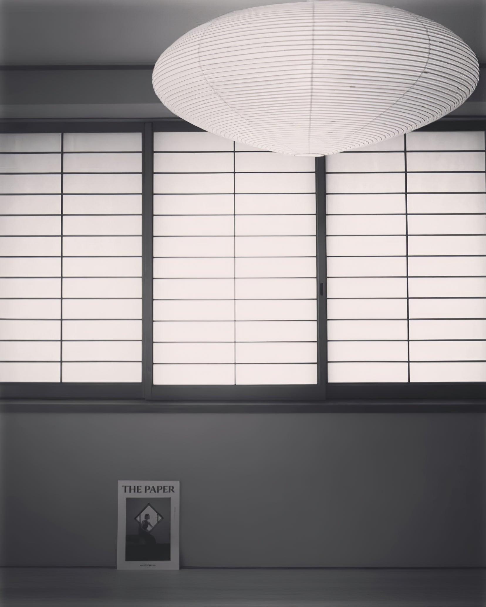 Ribbed White paper shade above black-framed translucent sliding panels with a booklet below