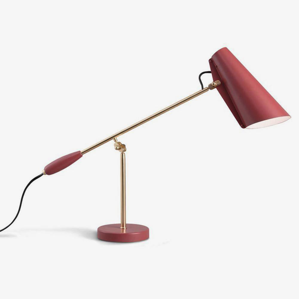 Isolated red table lamp with smooth cone shade, long gold-toned arm, round red base and black cable