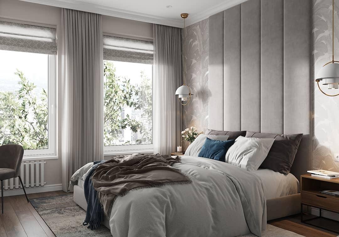 White-and-gold pendants flanking a bed with a padded wall behind it.