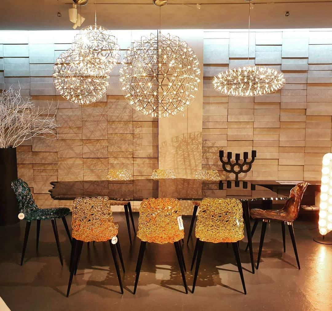 Globe lighting display above a black table with patterned chairs and a flattened ring fitting