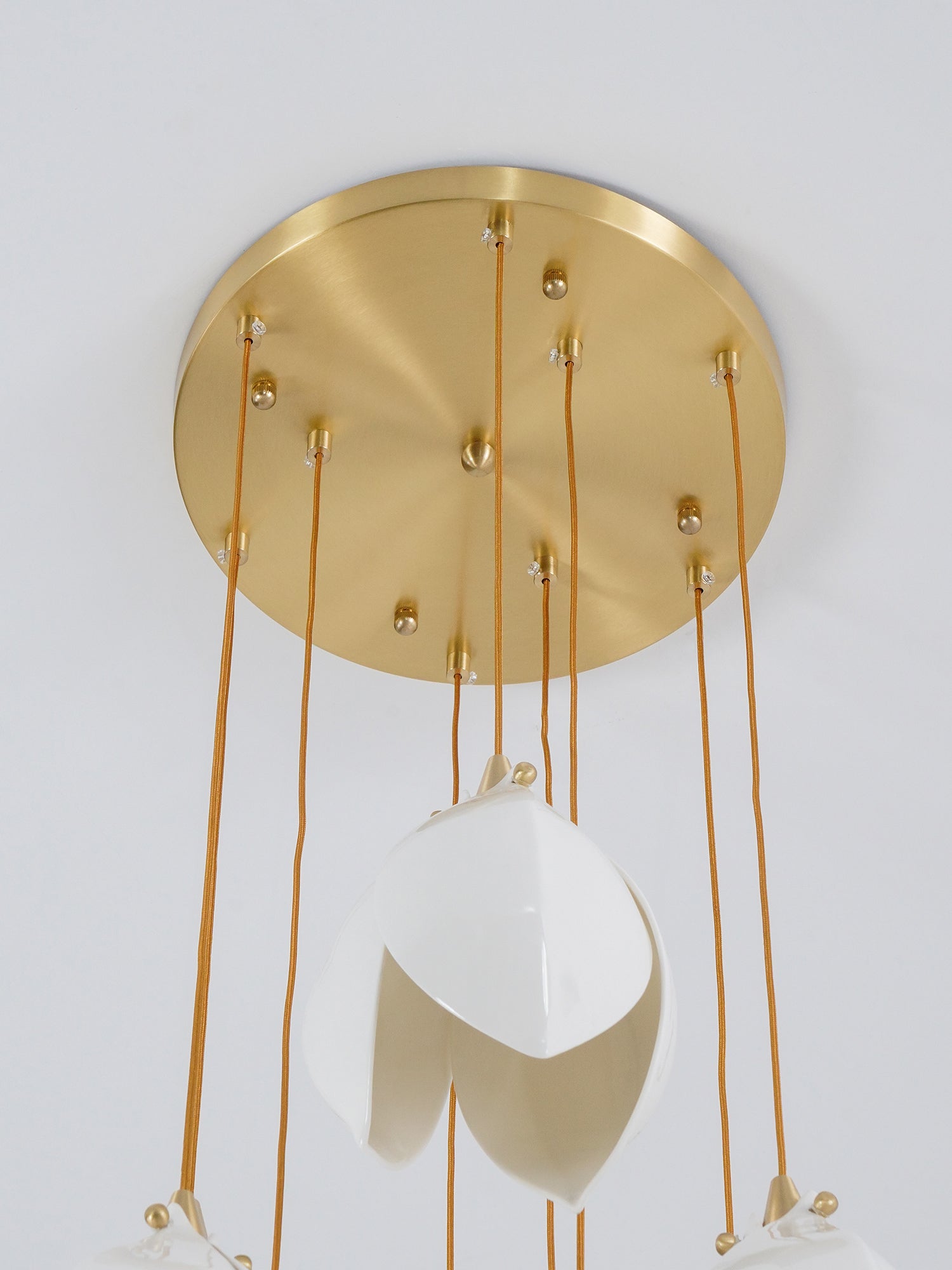 Round gold-tone canopy viewed from below with cords and white flower petals