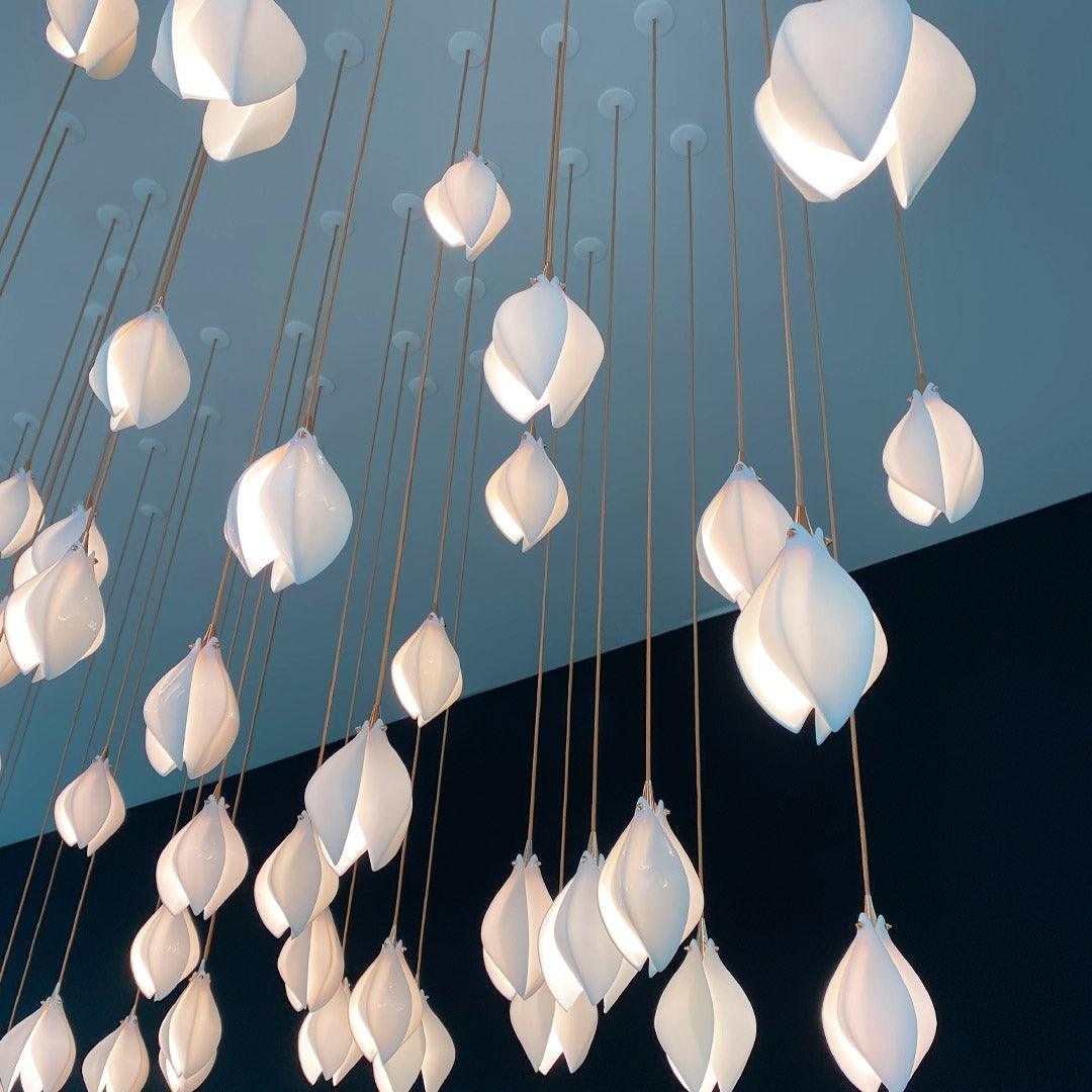 White petal pendants viewed from below against a blue ceiling and wall