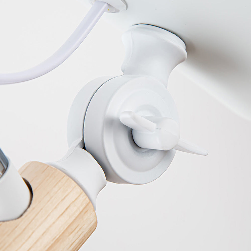 Closeup of White head joint with wing-like fastener beside wood-toned connector and looped cable