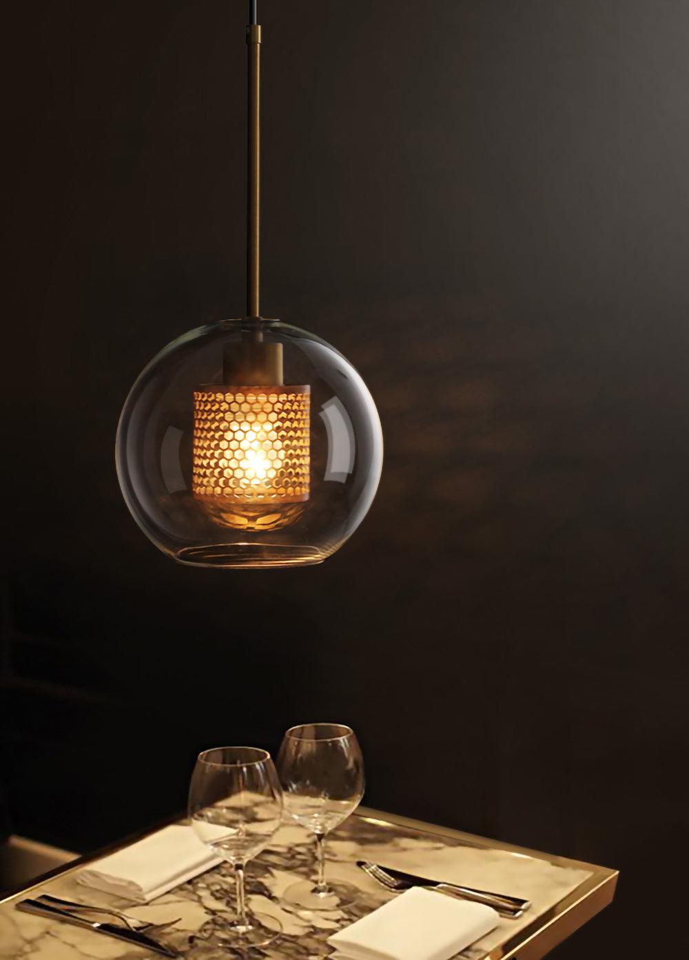 Single glowing glass pendant above a set table