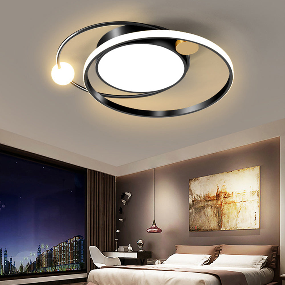 Black orbital ceiling fixture above a bedroom with gold abstract art, night window and a separate pendant light