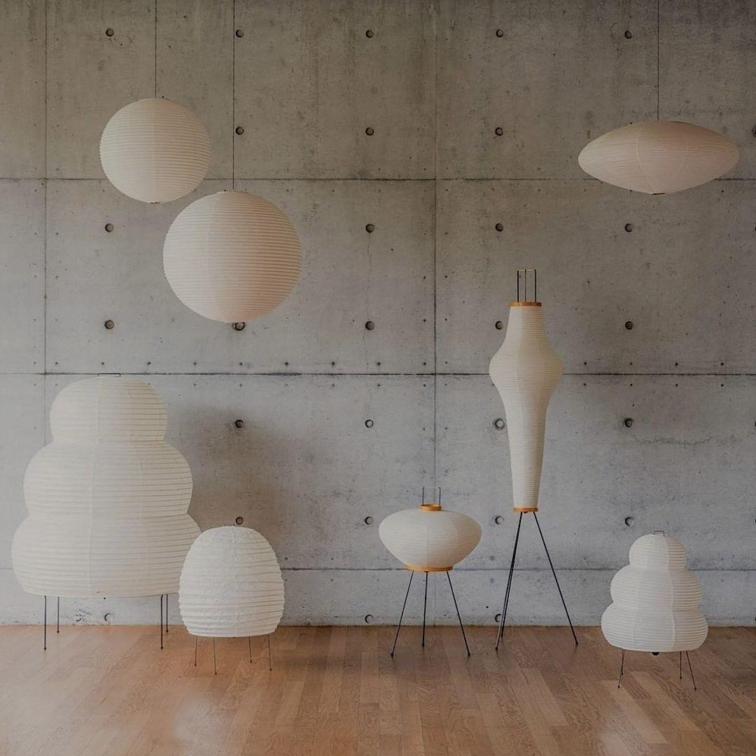 Paper floor, table and pendant lamps displayed against a concrete wall and wooden floor