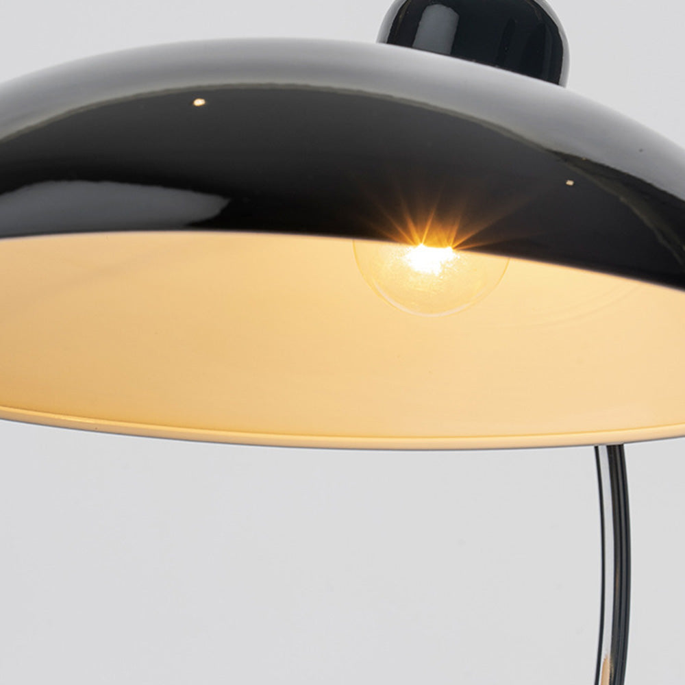 Close view beneath black dome shade showing a pictured lit round bulb and pale interior