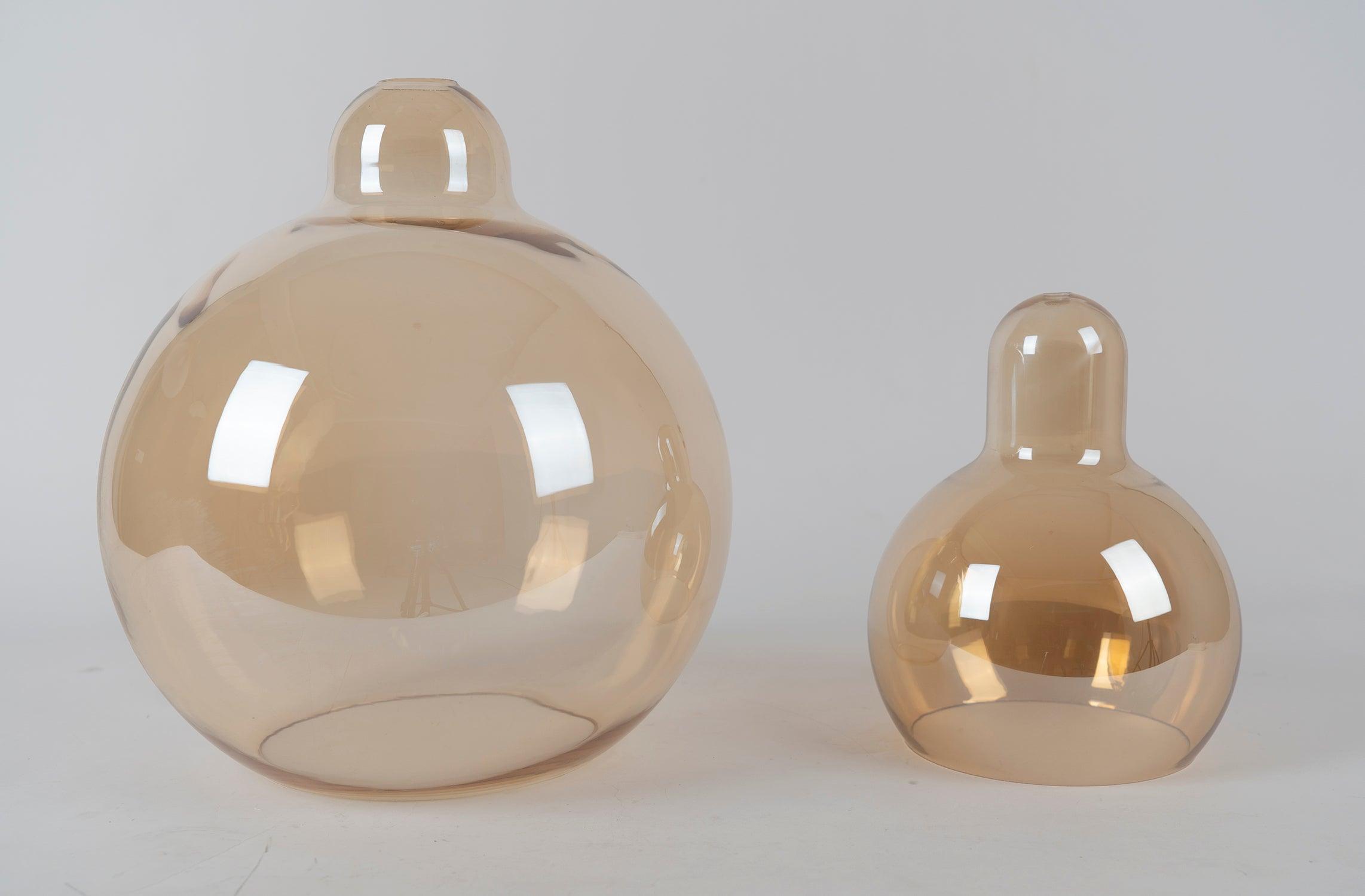 Two amber-coloured glass shades without fittings