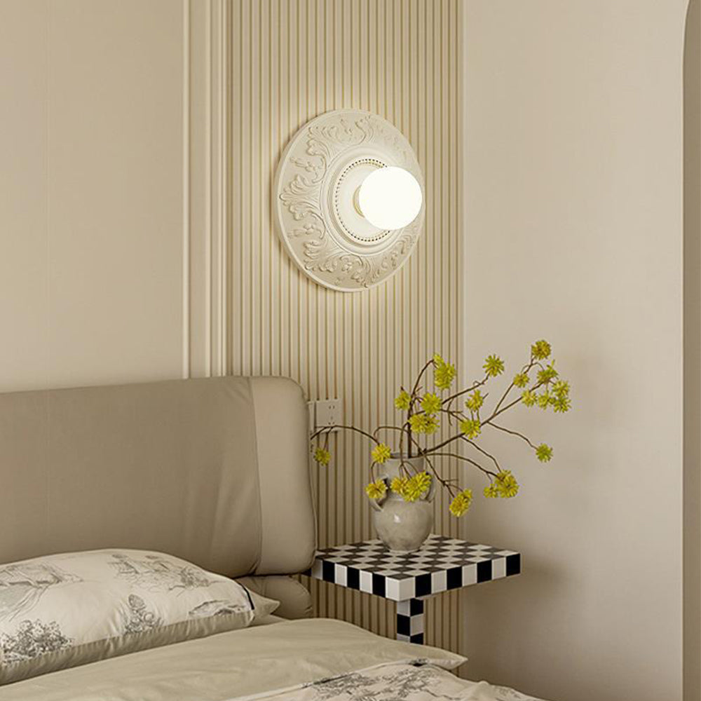 Angled projecting globe above a sofa, checkerboard side table and vase of yellow flowering branches