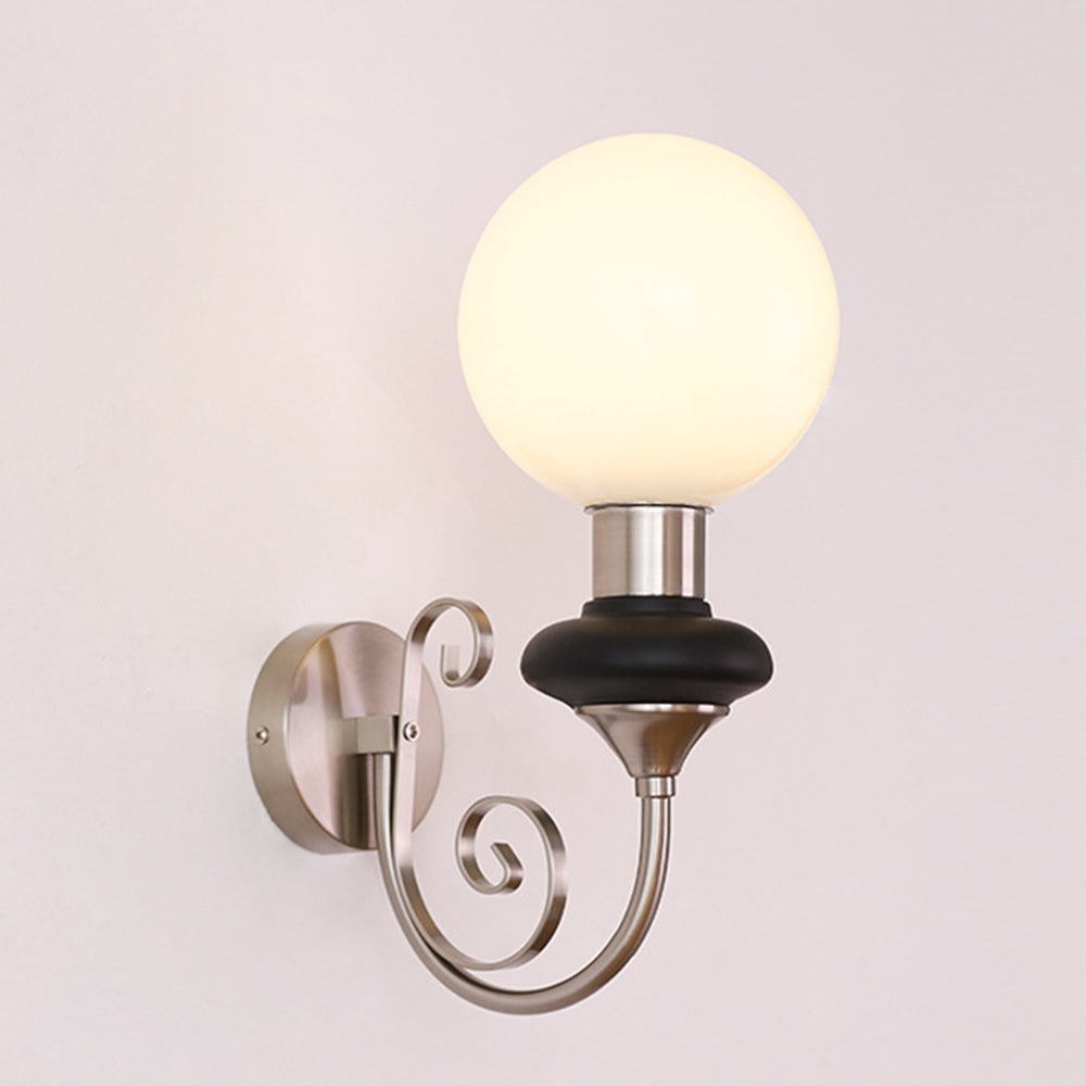 Chrome-and-black scroll-arm globe sconce isolated