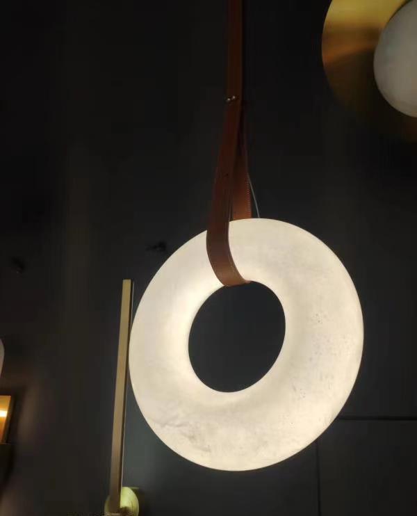 Illuminated vertical Oslo ring on a brown strap in a dark setting.