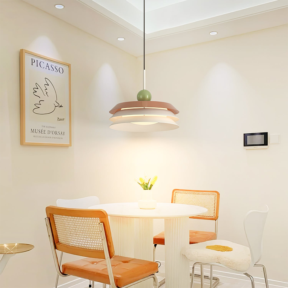 Morandi red-toned and pale three-tier pendant above a round dining table beside framed bird artwork