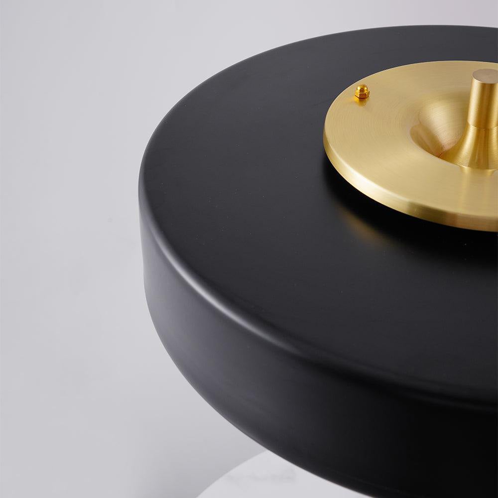 Close-up of black shade surface and gold-toned circular top cap with small fittings