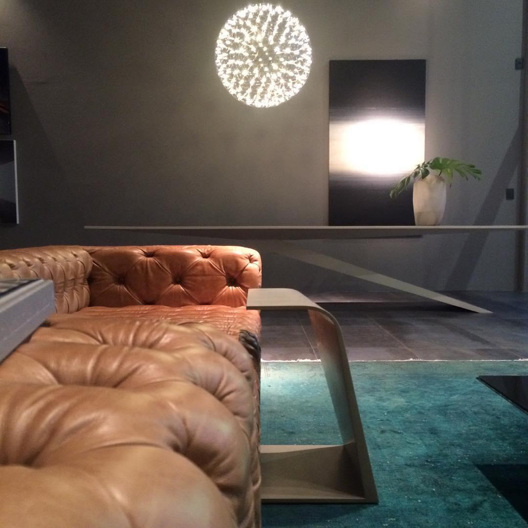 Lattice globe over a white dining table beside a tan sofa and teal rug