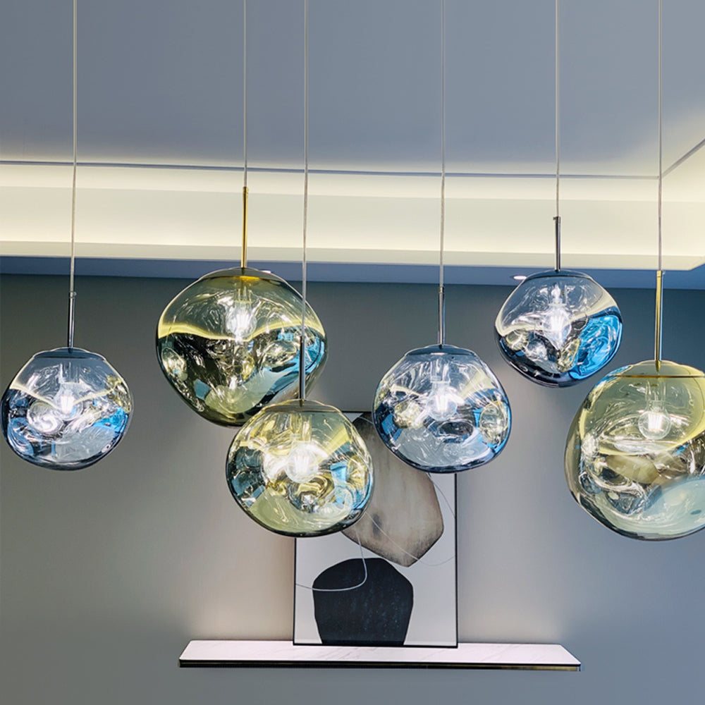 Reflective Gold and Silver shades above a white console with an abstract print against a grey wall