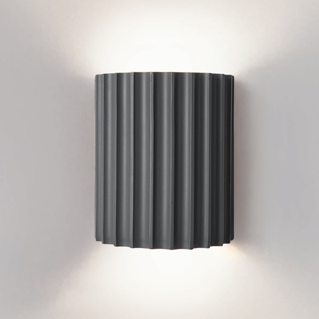 Front view of a grey half-round ribbed wall shade with light visible above and below
