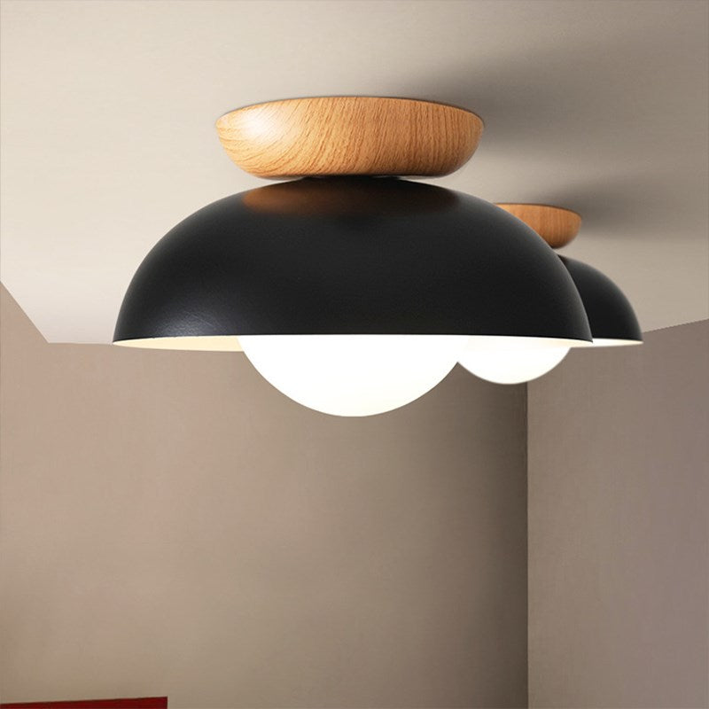Close-up of Black dome ceiling lights with wood upper accents and glowing round faces
