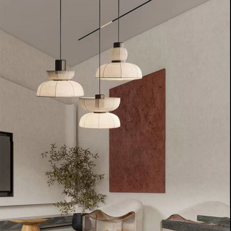 Three different ribbed pendant profiles above tables near a large red wall artwork
