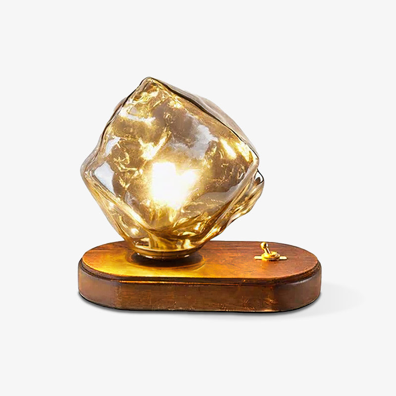 Isolated glowing Ice Stone lamp with irregular glass and a toggle at the right of its oval wood base