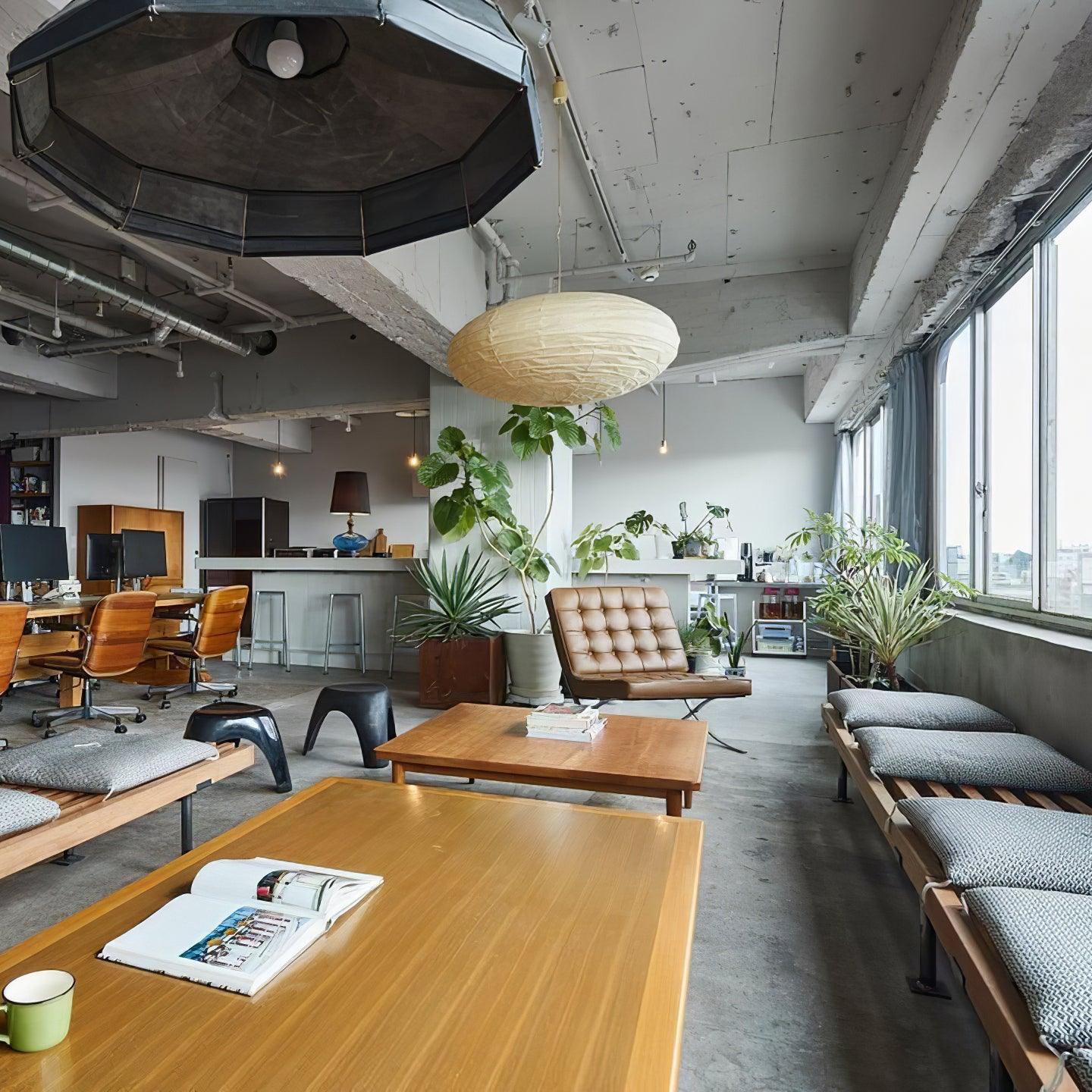 Flattened paper pendant in a plant-filled loft above wood coffee tables, cushioned benches and a brown chair
