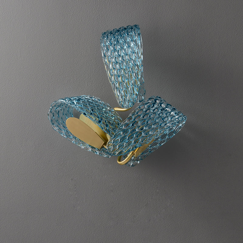 Unlit three-loop blue glass wall light with oval texture and gold-tone inner plates