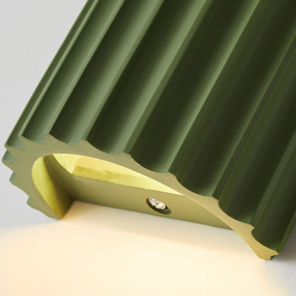 Close underside of a green ribbed wall shade with pale interior and screw on the fixing strip