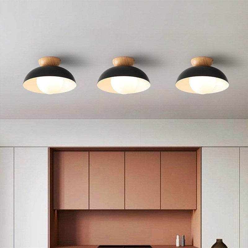 Three separate Black dome ceiling lights with wood accents arranged above a cabinet