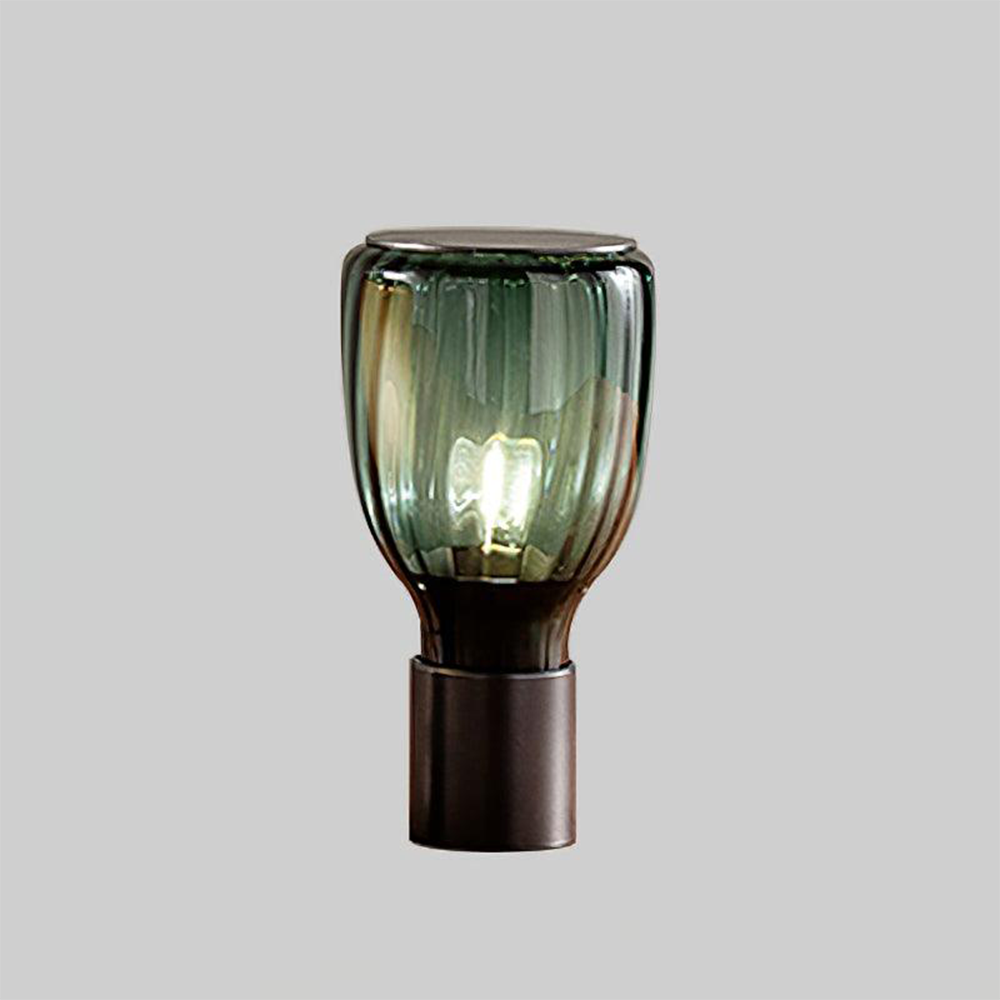 Dark Green ribbed glass lamp showing the central bulb silhouette and reflections above its black base