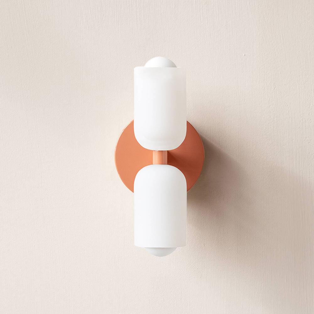 Pink-option wall sconce pictured with a peach-coral plate and two creamy-white cup shades, unlit