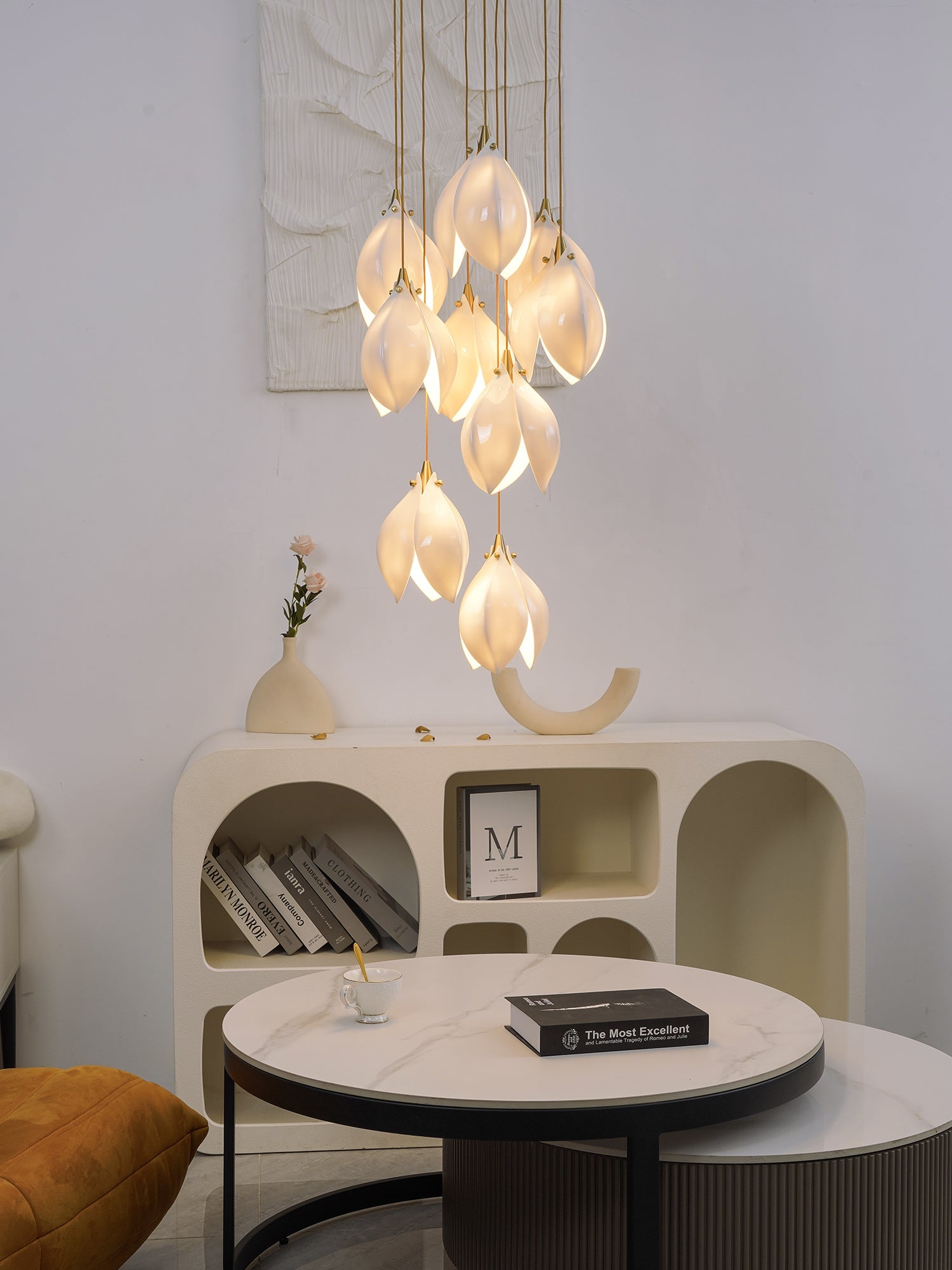 Glowing flower buds above an arched console with books, vases and round coffee tables