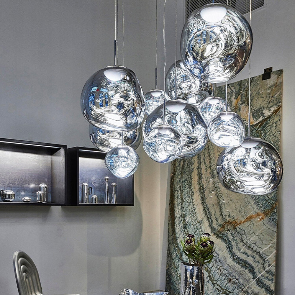 Close view of reflective Silver shades beside a veined wall panel, metallic flower vase and framed displays