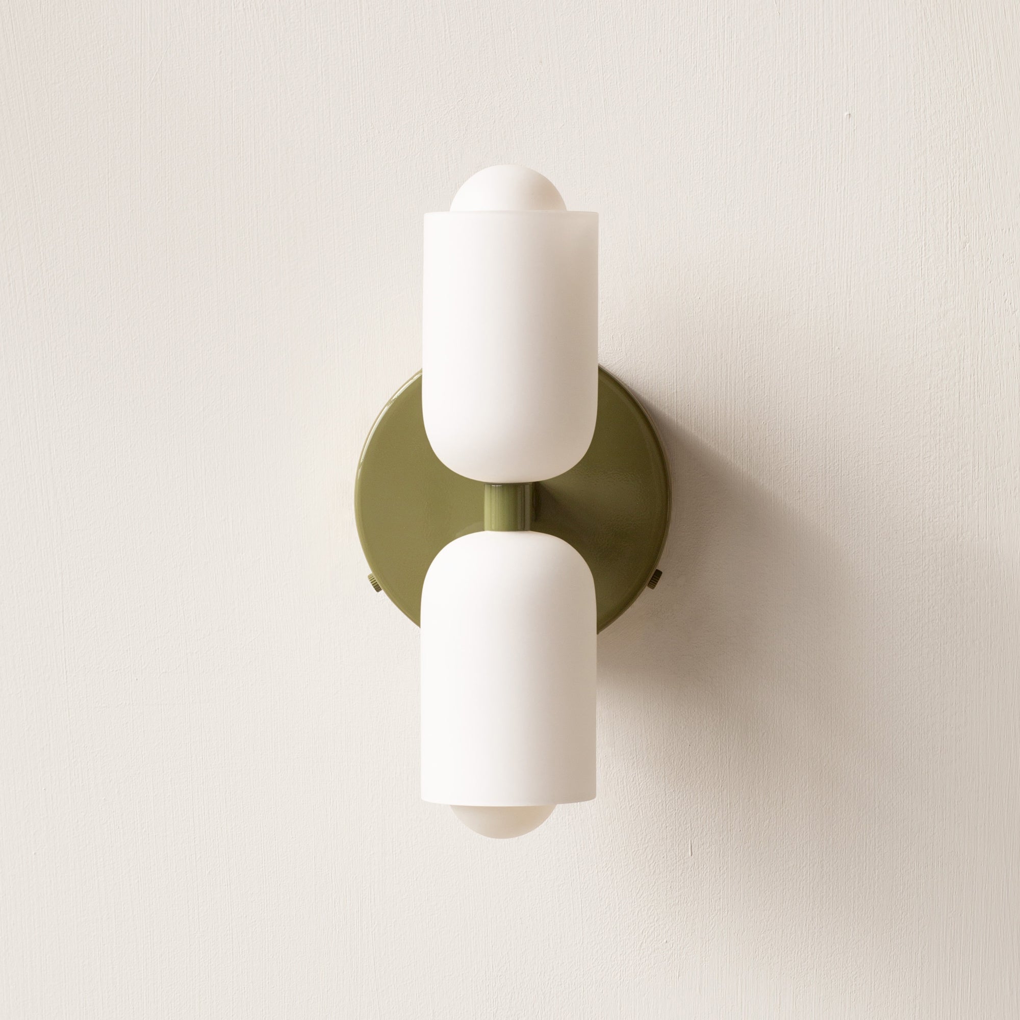 Green double-head wall sconce with olive-green round plate and creamy-white upper and lower shades